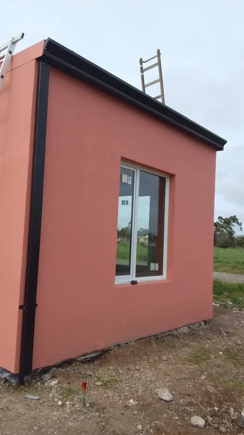 Vivienda de 30 m² terminada en color terracota, en campo bonaerense