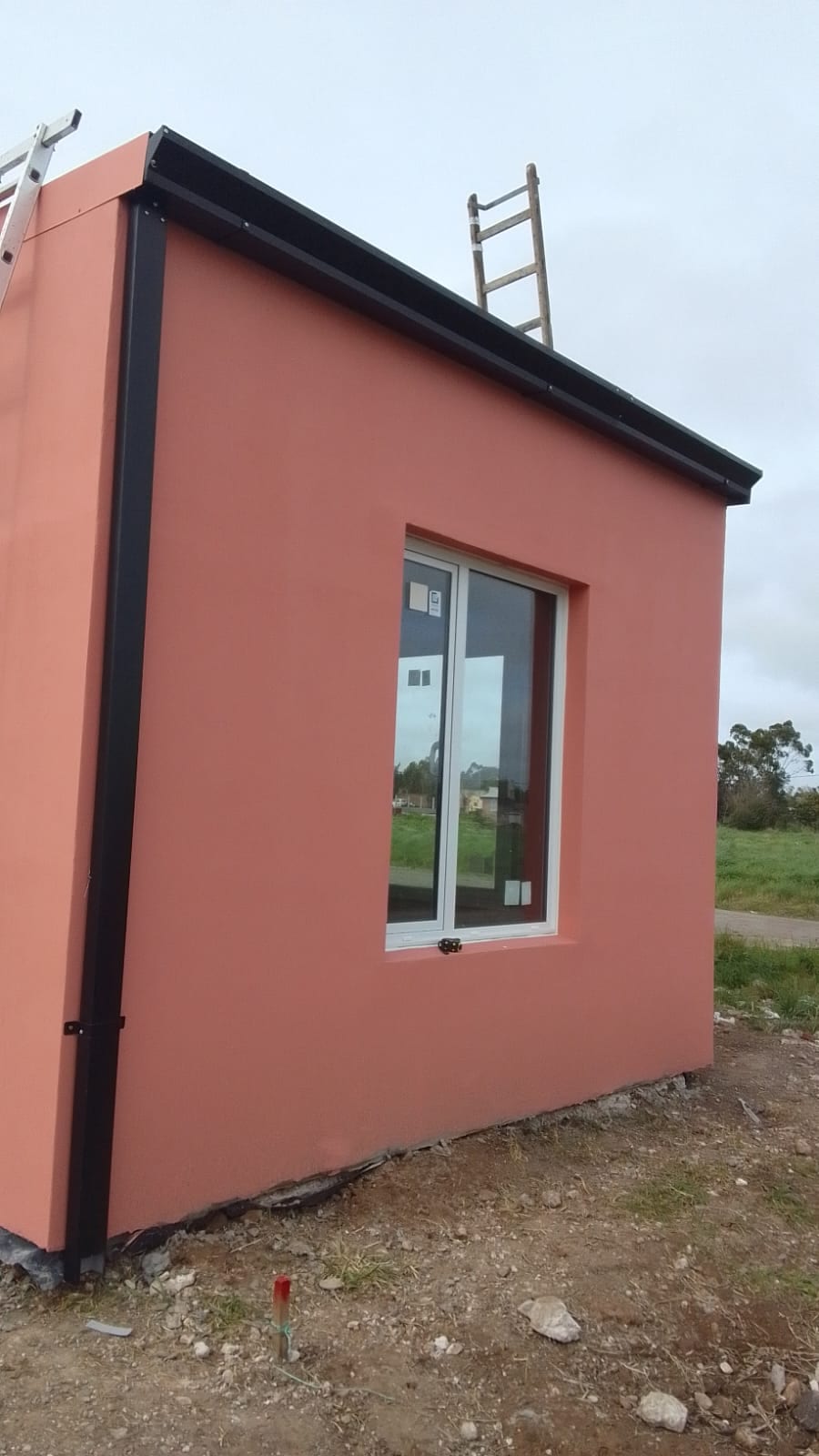 Vivienda de 30 m² terminada en color terracota, en campo bonaerense